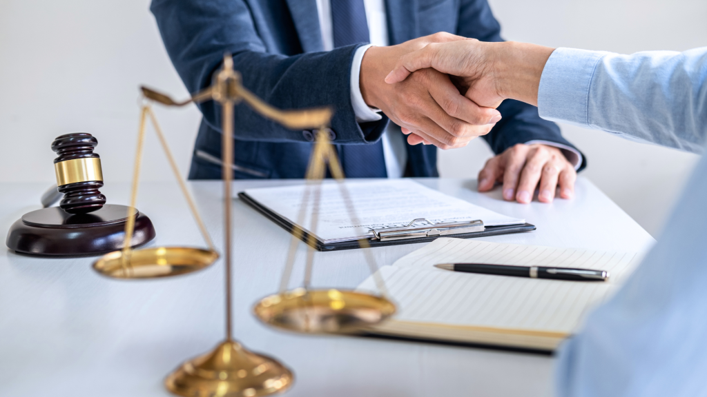Abogado estrechando la mano con un cliente durante una asesoría legal para la compra de una propiedad en España