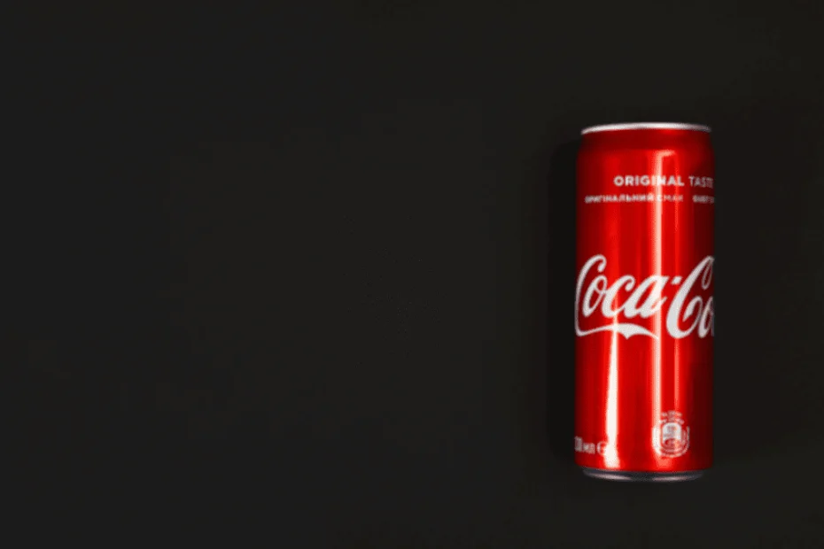 Lata de Coca-Cola de color rojo brillante con el logotipo blanco característico, colocada sobre un fondo negro liso. La imagen destaca la identidad visual reconocida globalmente de la marca Coca-Cola, lo que refuerza la importancia de proteger una marca en el extranjero frente a imitaciones o usos no autorizados.