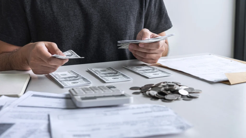 Empresario contando dinero y revisando documentos para reclamar deuda a empresa extranjera en concurso de acreedores en la UE