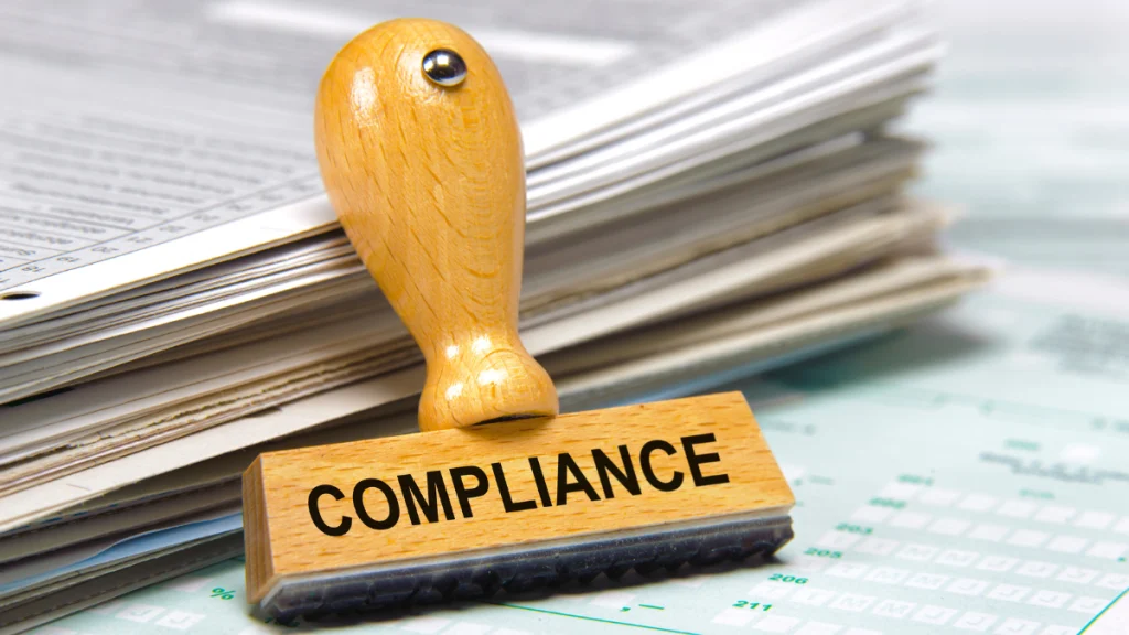 Sello apoyado e documentación, en él encontramos la palabra compliance escrita de forma horizontal