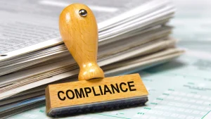 Sello apoyado e documentación, en él encontramos la palabra compliance escrita de forma horizontal