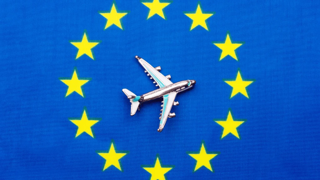Avión sobre bandera de la Unión Europea representando la movilidad laboral con la Tarjeta Azul UE en España 2025.