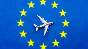 Avión sobre bandera de la Unión Europea representando la movilidad laboral con la Tarjeta Azul UE en España 2025.