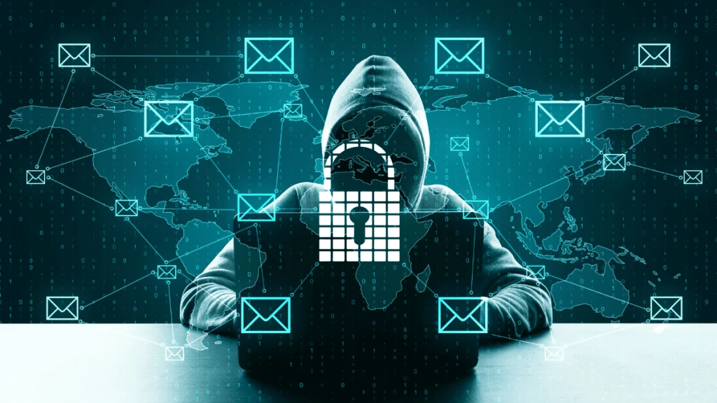 Imagen conceptual de un hacker encapuchado usando una computadora portátil en un entorno oscuro, con un candado digital superpuesto en el centro que simboliza ciberseguridad. Al fondo, un mapa mundial conectado por iconos de sobres de correo electrónico y líneas que representan el intercambio de datos y posibles ciberataques a nivel global.
