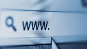 Primer plano de una pantalla de computadora que muestra una barra de direcciones web, donde se observa el texto “www.” junto al ícono de una lupa, que representa la función de búsqueda. La imagen está ligeramente pixelada, lo que sugiere un enfoque macro sobre la pantalla, y transmite una temática relacionada con internet o navegación web.