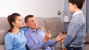 Padres separados conversando con su hijo en casa sobre el plan de parentalidad internacional, simbolizando la comunicación familiar y los acuerdos de custodia compartida entre países.