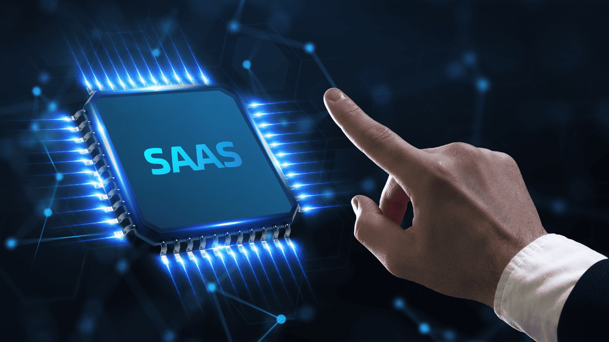 Mano señalando un microchip brillante con la palabra “SAAS” sobre fondo de red digital.