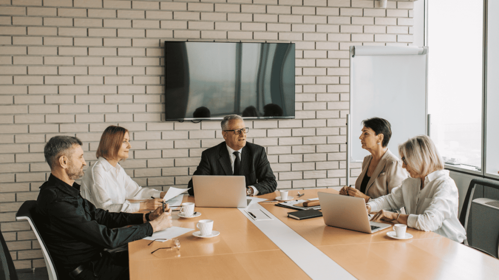 Reunión de socios en empresa tecnológica para revisar acuerdos y tomar decisiones.