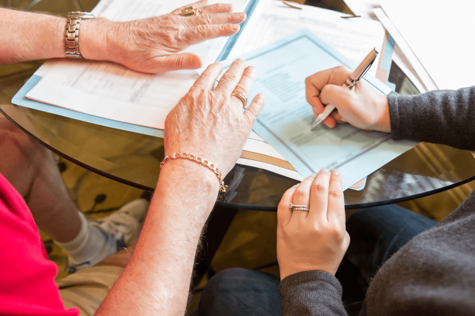 Impugnar testamento internacional: asesoría legal revisando documentos y firmando formularios sobre competencia judicial en España.