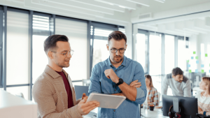 Partners in a company analyzing options with a document held by one of them.