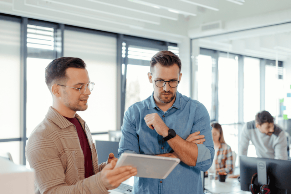Socios de una empresa analizando opciones con un documento sujetado por uno de ellos.